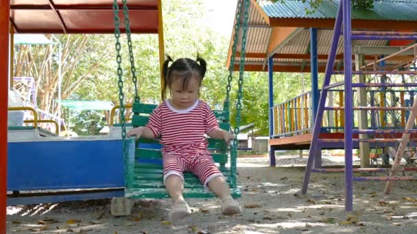 Chica jugando swing silla en parque — Vídeos de Stock