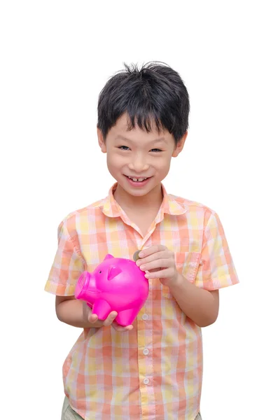 Boy inserting coin into piggy bank — Stock Photo, Image