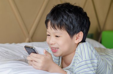 Akıllı telefondan oyun oynayan çocuk