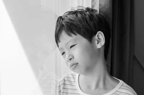 Sad boy looking out of window — Stock Photo, Image