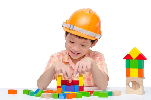 Menino com capacete jogando bloco na mesa — Fotografia de Stock