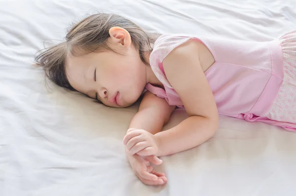 Flicka sover på sängen — Stockfoto