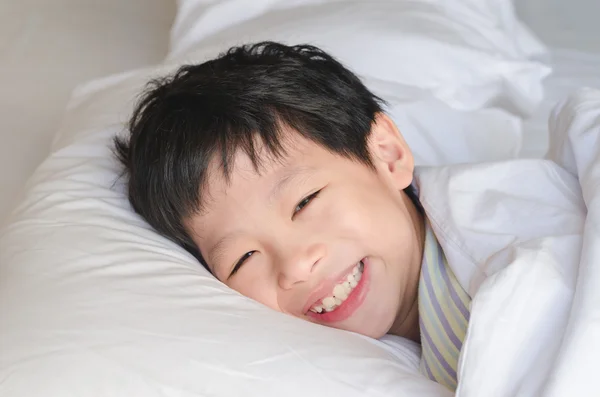 Oğlan gülümsüyor uyan yatakta sonra — Stok fotoğraf