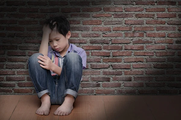 Sad boy sitting on the floor — Stock Photo, Image