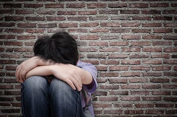 Sad boy sitting on floor — Stock Photo, Image