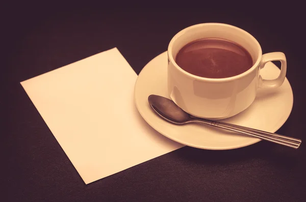 Taza de café y nota de papel en la mesa — Foto de Stock