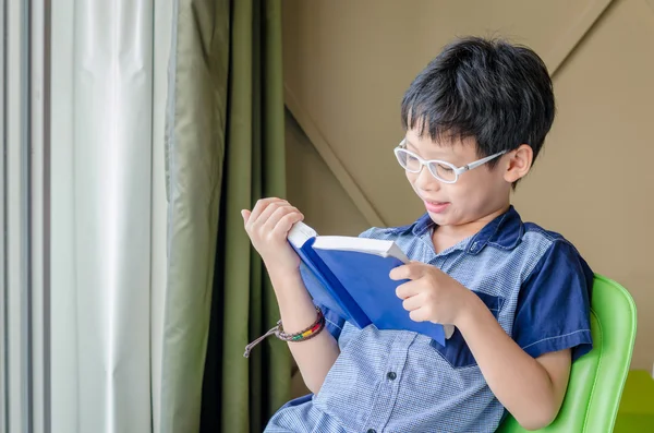 Jongen leesboek op kamer — Stockfoto