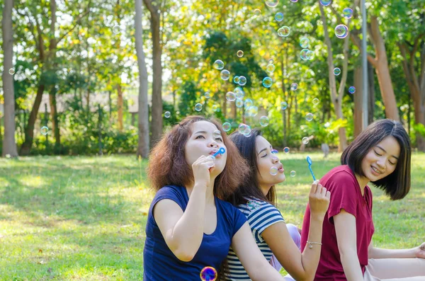 Жінки дмуть мильні бульбашки в парку — стокове фото