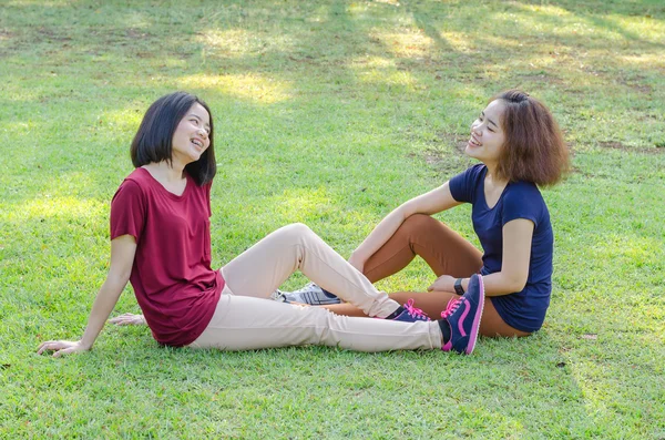 Meninas sentadas no campo de grama após o exercício — Fotografia de Stock