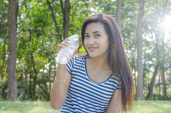 公園で水のボトルを保持している女性 — ストック写真