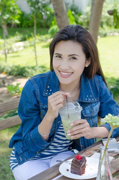 Aziatische vrouw ijs greentea en taart eten in restaurant — Stockfoto