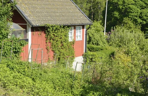 Idyllic red cottage in botanical garden — Stock Photo, Image