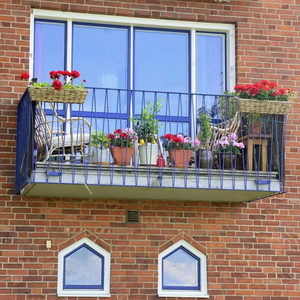 Modern apartman binasının mimari detayları. Sandalyeli ve çiçekli balkon