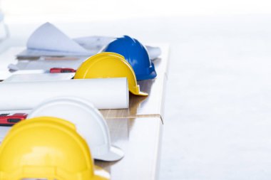 Planlar ve miğferler masanın üzerinde, mühendislik ve güvenlik kavramı