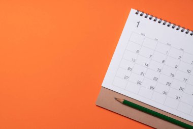 Takvimi turuncu masa arka planında kapat, iş toplantısı ya da seyahat planı yeni yıl konsepti