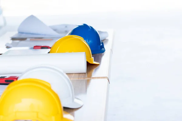 Blueprint and helmets on the table, engineering and safety concept — Stock Image Blueprint Helmets Table Engineering Safety Concept Royalty Free Stock Images