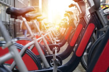 Şehir yolu parkında güneş ışığı ve toplu taşıma konseptiyle bisiklet kiralama hizmeti.