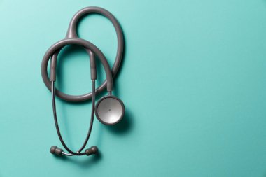 Yeşil arka planda steteskopun üst görüntüsü, sağlıklı konsepti kontrol etmek için program
