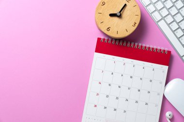 Pembe masa arkaplanındaki takvim, klavye, bilgisayar ve alarm saatini kapat, iş toplantısı ya da seyahat planlama konseptini planla