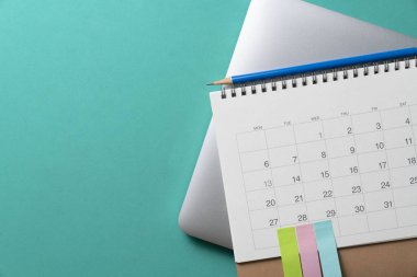 Takvim ve bilgisayar defterini yeşil masa arkaplanına kapat, iş toplantısı ya da seyahat planlama konseptini planla