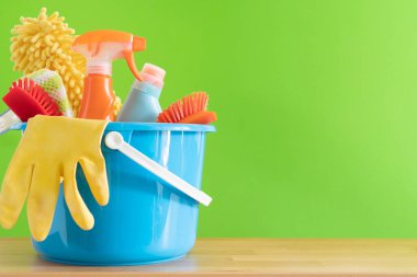 Ahşap masa üzerinde ev temizleme ürünü yeşil arka plan, ev servisi veya temizlik konsepti