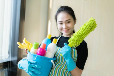 Temizlik malzemesi olan Asyalı kadın temizlik ya da ofis temizliğine hazır.