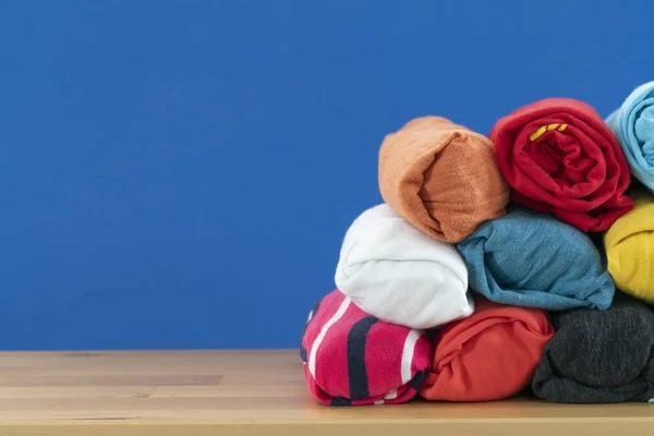 Zblízka Válcované Barevné Tričko Oblečení Dřevěném Stole Modrým Pozadím Cestovní — Stock fotografie