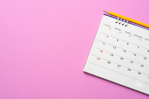 close up of calendar on the pink table background, planning for business meeting or travel planning concept