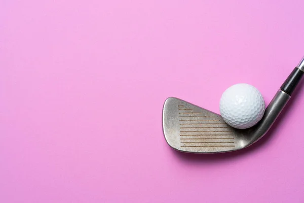 ピンクの背景にゴルフボールとゴルフクラブ — ストック写真