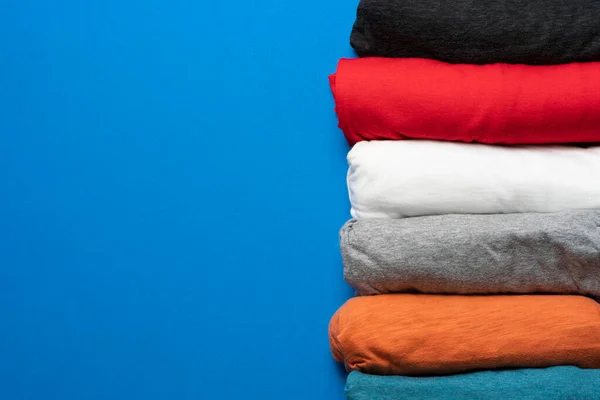 Gros Plan Des Vêtements Shirt Colorés Roulés Sur Fond Table — Photo