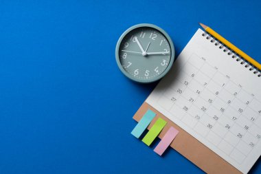 mavi masa arkaplanındaki takvim ve alarmın kapatılması, iş toplantısı ya da seyahat planlama konsepti