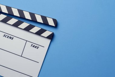 Mavi masa arka planında film alkışları; film, sinema ve video fotoğrafçılığı kavramı