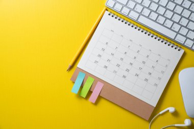 sarı masa arkaplanındaki takvim ve bilgisayar klavyesini kapat, iş toplantısı ya da seyahat planlama konseptini planla