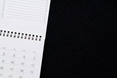 Takvimi siyah masa arka planında kapat, iş toplantısı veya seyahat planlama konsepti için planlama