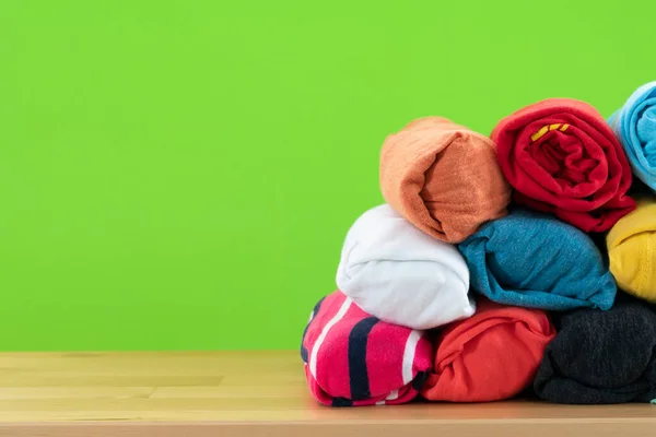 Nahaufnahme Von Gerollten Bunten Shirt Klamotten Auf Holztisch Mit Grünem — Stockfoto