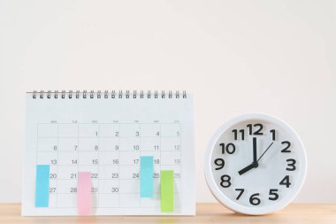 Masadaki takvim ve alarmın kapatılması beyaz arka plan, iş toplantısı veya seyahat planlama konsepti