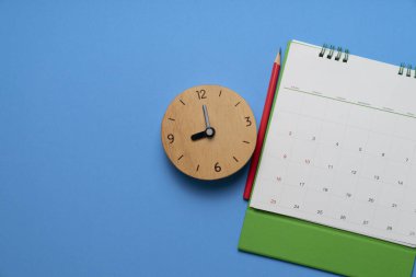 mavi masa arkaplanındaki takvim ve alarmın kapatılması, iş toplantısı ya da seyahat planlama konsepti