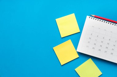 mavi masa arkaplanındaki takvimi kapat, iş toplantısı ya da seyahat planlama konsepti için planlama