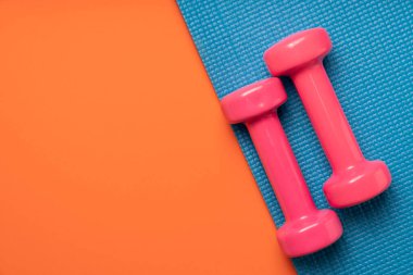 Masada pembe dambıl ve mavi yoga minderi, spor ve spor konsepti.