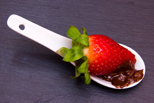 Teaspoon with strawberry and chocolate on top slate — Stock Photo, Image