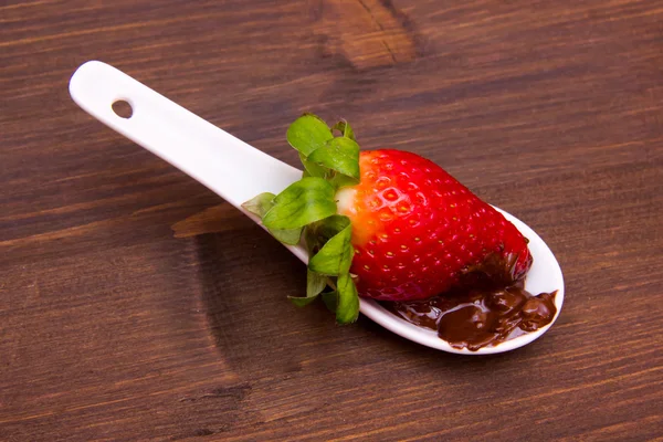 Cucharadita con fresa y chocolate encima de la madera —  Fotos de Stock