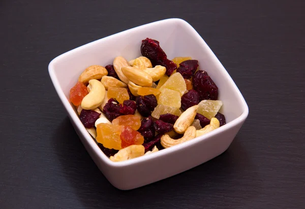 Dried fruits on square bowl on slate — Stock Photo, Image