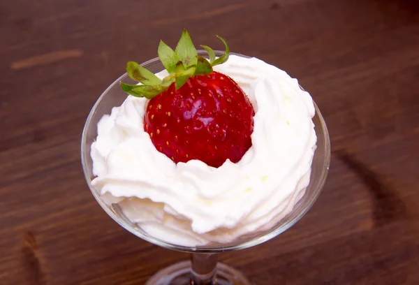 Cristal con fresa y crema sobre madera de cerca — Foto de Stock