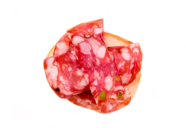 Snee brood met plakjes salami met pistachenoten van bovenaf — Stockfoto