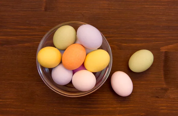 Uova colorate all'interno ciotola su legno dall'alto — Foto Stock