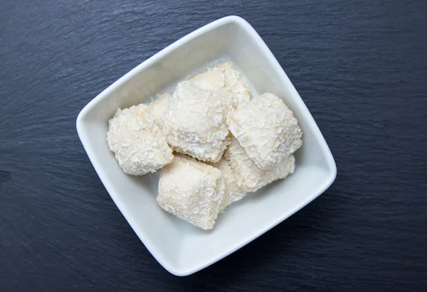 Cakes with coconut on a square bowl on top slate — Stock Photo, Image