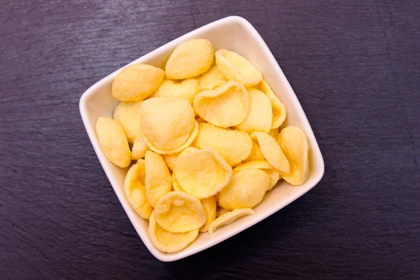 Aardappel snack op vierkante kom op leisteen van bovenaf gezien — Stockfoto