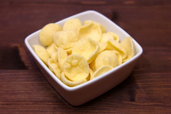 Collation de pommes de terre sur bol carré sur bois — Photo