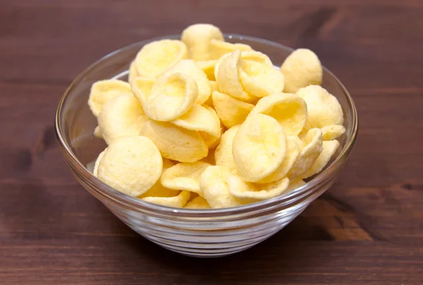 Potato snacks on bowl over wood — Stock Photo, Image