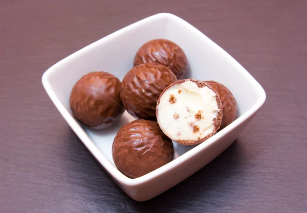 Pralinés de chocolate en tazón cuadrado en pizarra —  Fotos de Stock